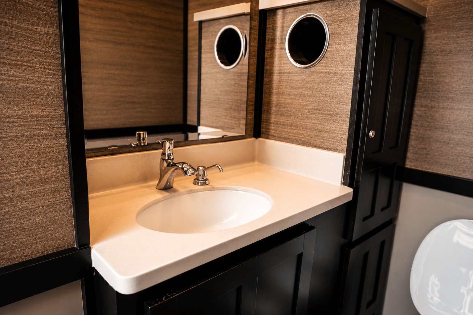 Premier Luxe Lounge Luxury Restroom Trailer Interior – Boston MA Luxury restroom trailer interior with flushing toilet, vanity sink, urinal, and premium finishes for weddings and events in Boston MA